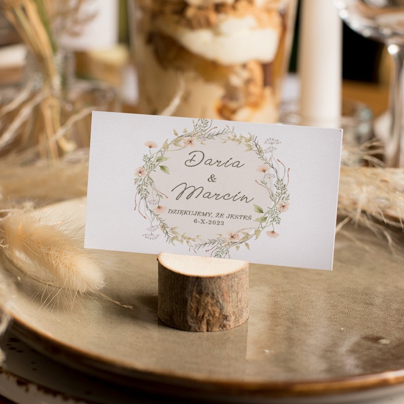 Topper na tort weselny w geometrycznym wzorze. W środku widoczne inicjały Młodej Pary. Naokoło dekorowany listkami.